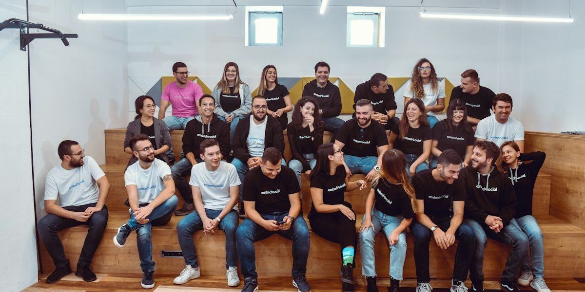 a group of people sitting on top of a wooden bench